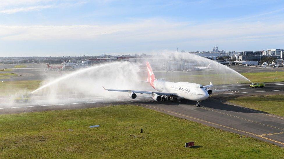 A Qantas Boeing 747-400, registration VH-OEJ receives a water cannon salute at Sydney Airport