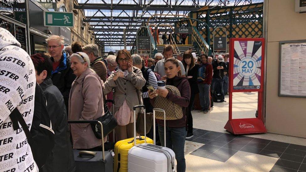 Dozens of people queue at Carlisle station as they wait for a replacement bus service