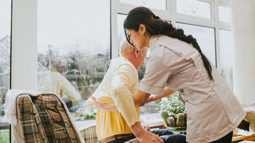 A home care worker helping an elderly person