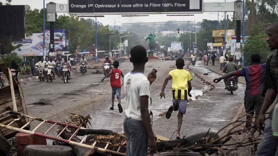 People run away at the arrival of the riot police as protesters set barricades in Bamako