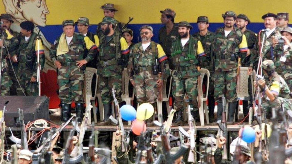 Colombian leftist commanders (L to R) Manuel Marulanda, known as "sureshot", Alfonso Cano, peace negociator Raul Reyes, Timochenko, Ivan Marquez and Jorge Briceno, all members of the general secretariat of the Armed Revolutionary Forces of Colombia (FARC), watch a parade of armed fighters at a camp in Villa Colombia near San Vicente del Caguan, Colombia, April 29, 2000