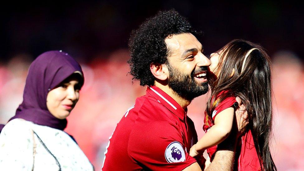 Mohamed Salah hugs his daughter Makka as wife watches