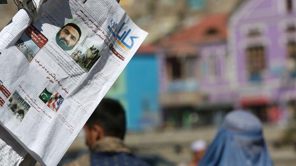 Newspapers hang for sale at a stand carrying headlines about the former leader of the Afghan Taliban, Mullah Mansour, in Kabul on 25 May