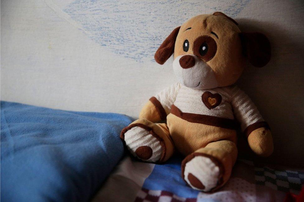 A cuddly toy sits on a bed in Punta de Rieles