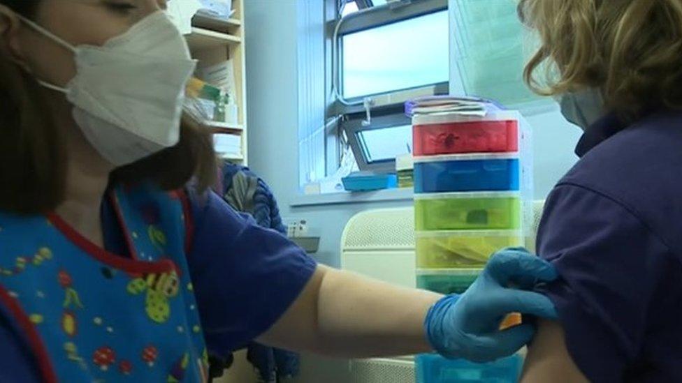 Nurse lifts child's sleeve for the vaccination