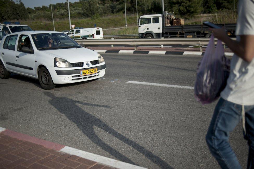 A young Israeli boy hitches a ride at the Nahshon bus junction in Nahson, Israel