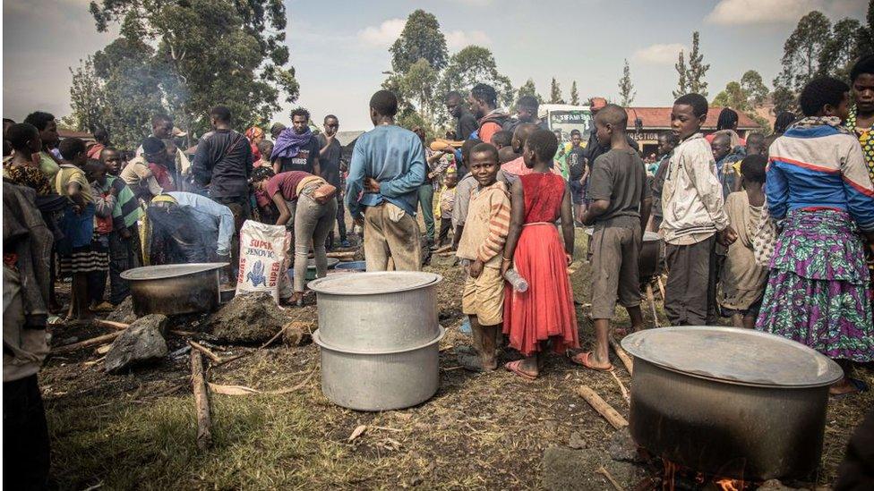 Volunteers prepare meals for Internal displaced people, fleeing the recent clashes between M23 rebels and Congolese soldiers, at a camp in Kanyarushinya north of Goma