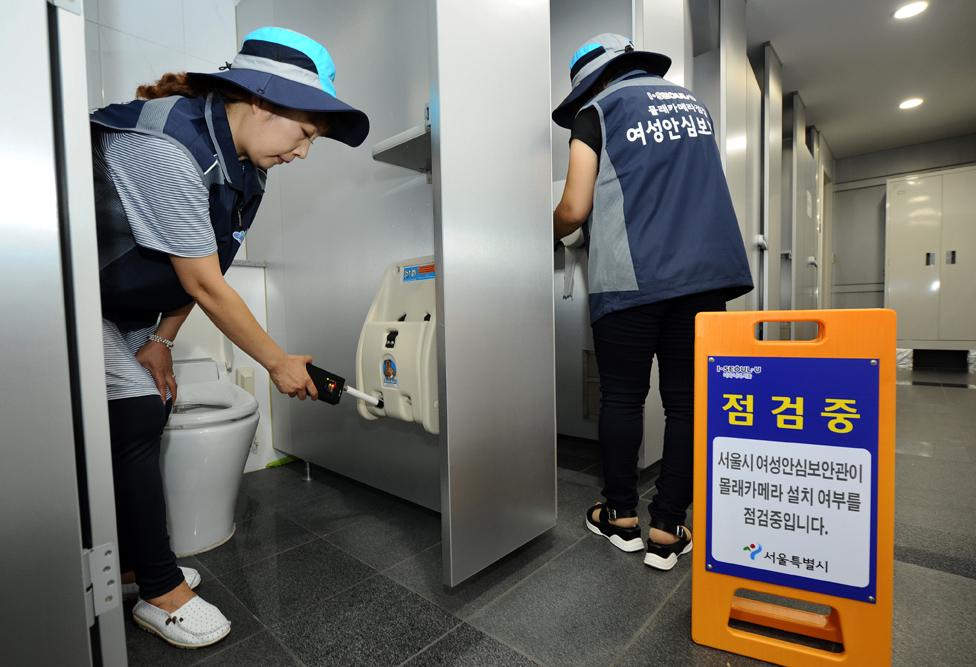 Two women checking toilets in Seoul