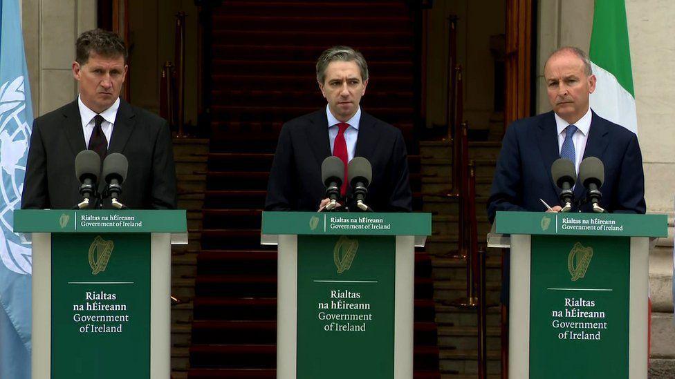 Ireland's coalition leaders speaking from podiums outside government buildings in Dublin