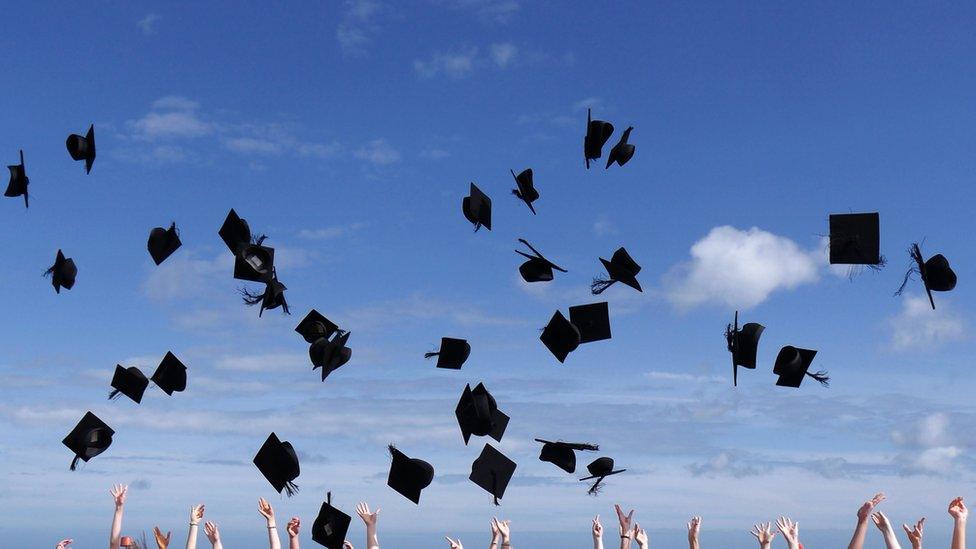 Graduation mortar hats thrown in the air