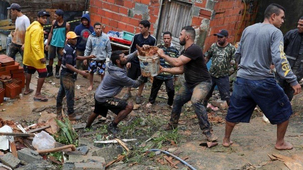 Residents in Guarujá clear the mud at the side of a landslide. Photo: 3 March 2020