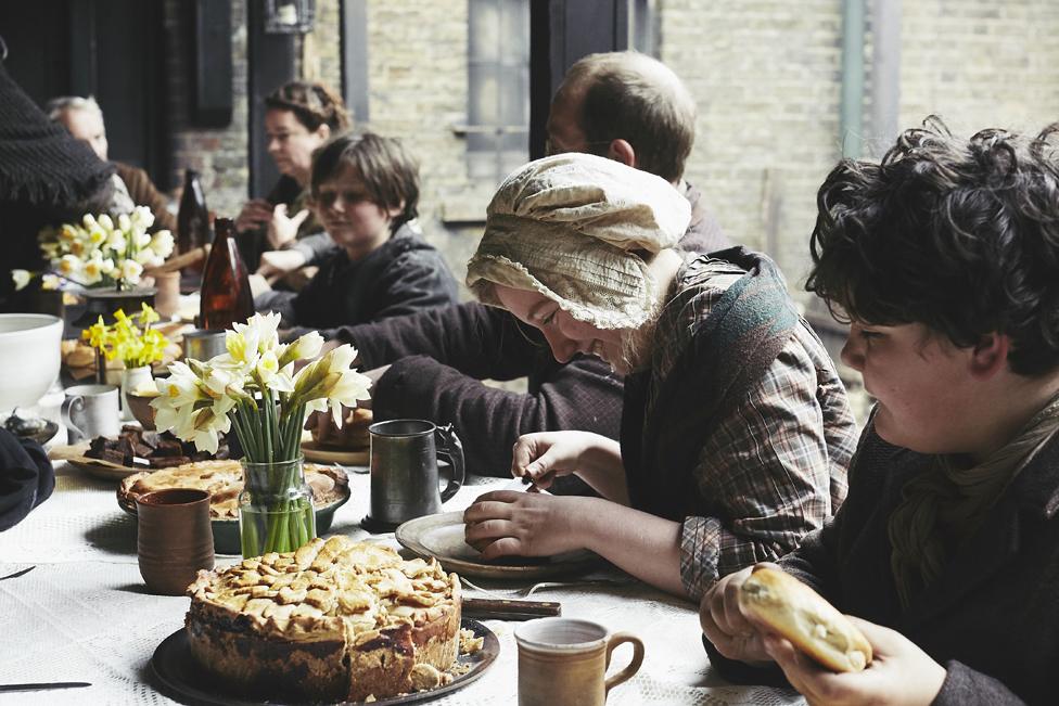 People dressed as Victorians having a Victorian-style meal