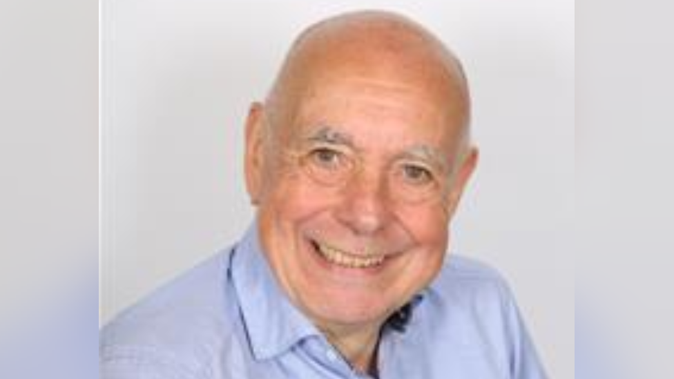 A man - Martyn Groucutt - smiles wearing a blue shirt. It is a head and shoulders shot of him. 