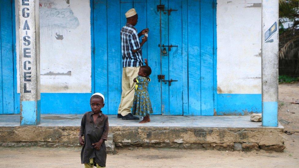 A shop owner closes down his shop on March 7, 2018 in Mocimboa da Praia, Mozambique