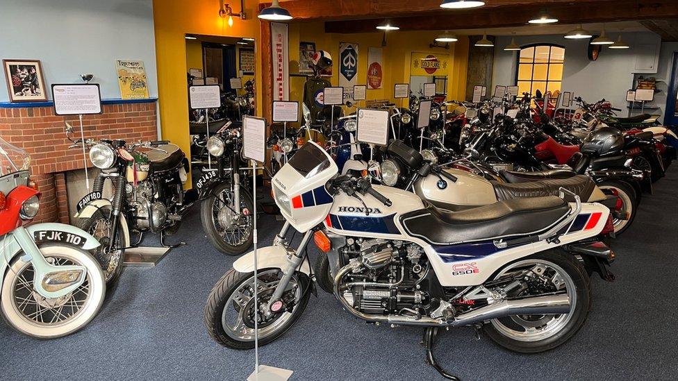 Dozens of classic motorbikes lined up inside the car museum