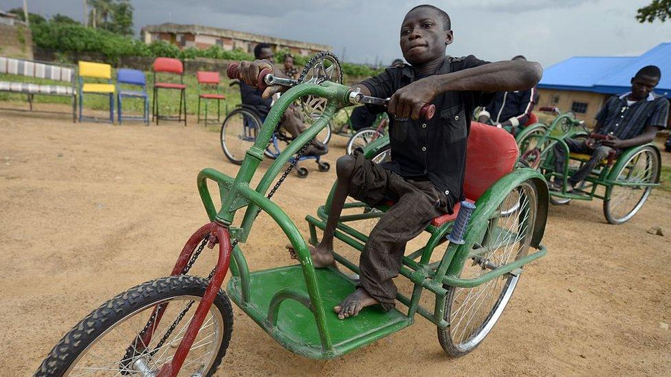 Jacob Clement rides on his new wheelchair in Nigeria