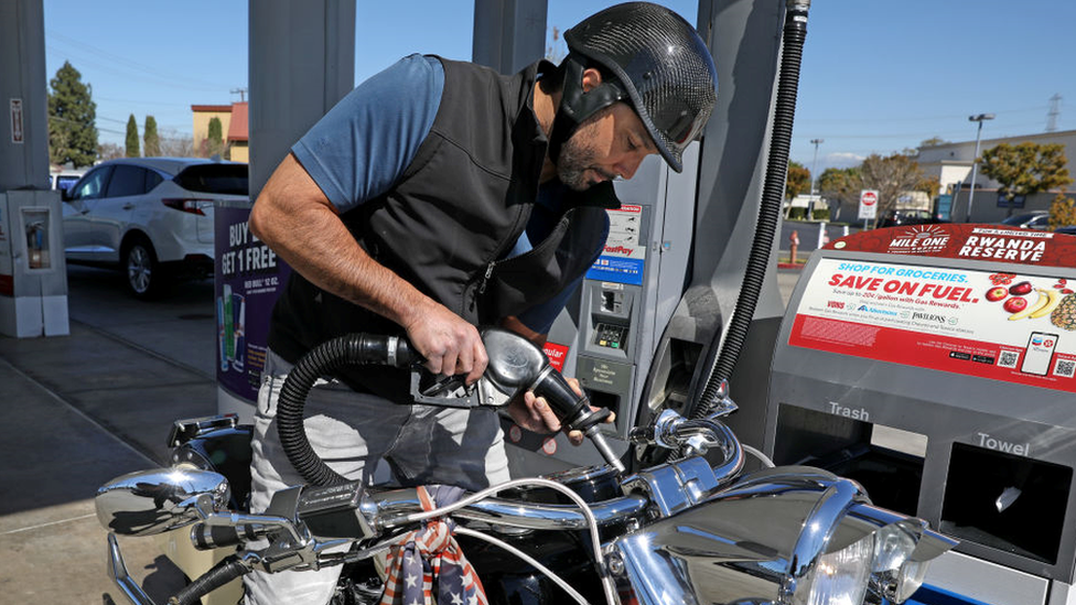 Man refuels bike at US petrol station