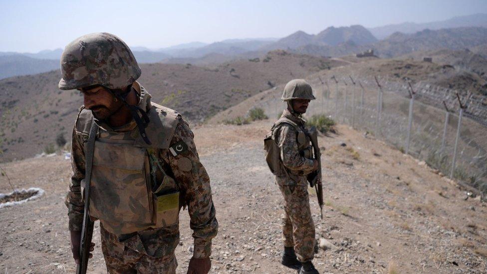 Pakistani soldiers patrol next to a newly fenced border fencing along Afghan border at Kitton Orchard Post in Pakistan's North Waziristan tribal agency on October 18, 2017