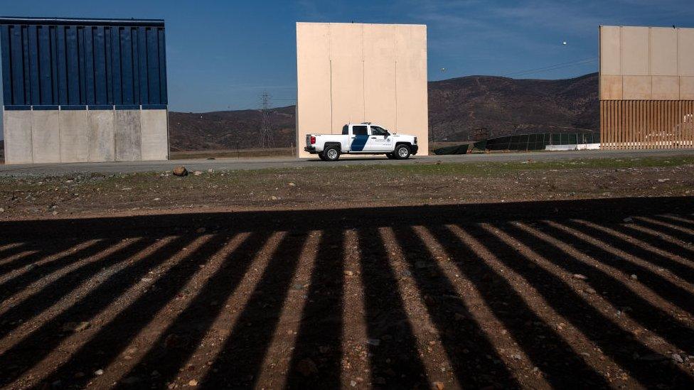 A US Border Patrol vehicle is seen near prototypes for Mr Trump's proposed wall