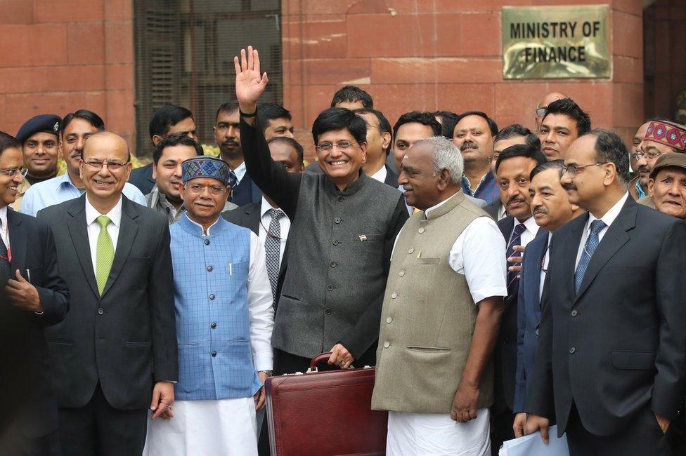 Indian Finance Minister Piyush Goyal (C) holds his briefcase, containing the Union Budget documents, as he poses for photos outside the Ministry of Finance for the Parliament House to present the 2019-20 General Budget in New Delhi, India.