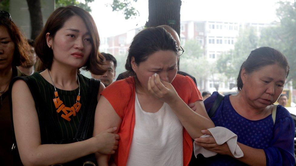 Fan Lili, centre, the wife of imprisoned activist Gou Hongguo, is escorted by Li Wenzu, left, the wife of imprisoned lawyer Wang Quanzhang, and another woman as they stage a protest outside the Tianjin No. 2 Intermediate People's Court in Tianjin, China, on 1 August 2016.