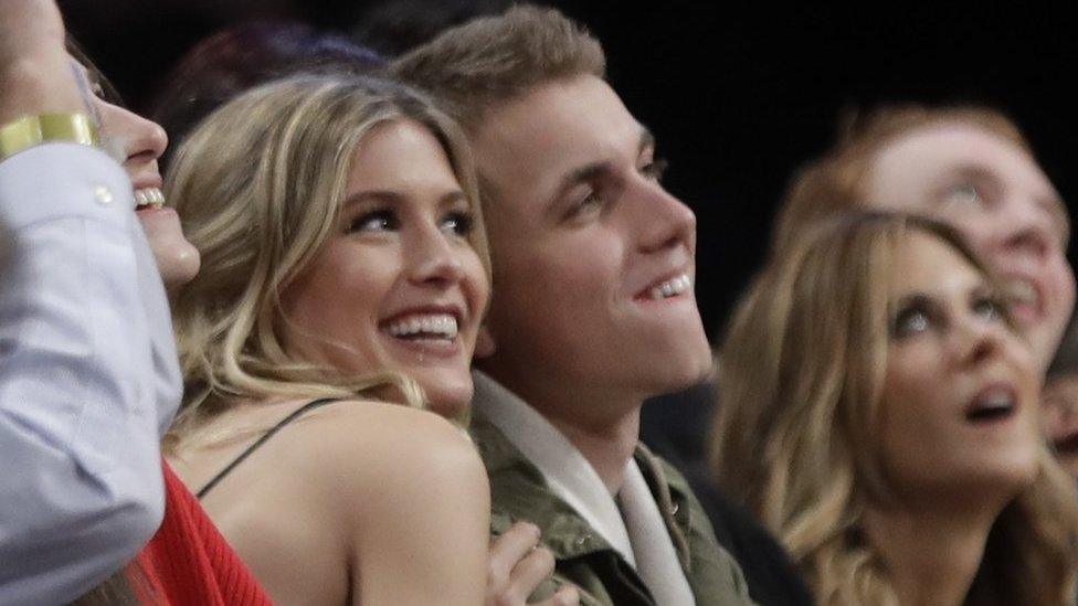 Eugenie Bouchard, left, poses for photographs with her blind date, John Goehrke, right, during the second half of an NBA basketball game