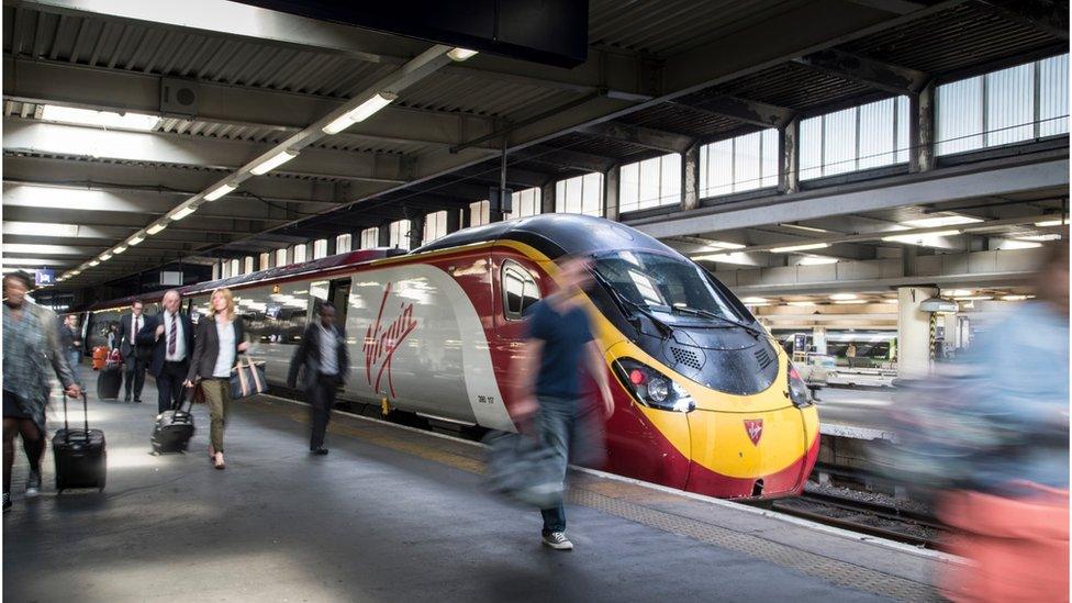 People disembark from a Virgin Train