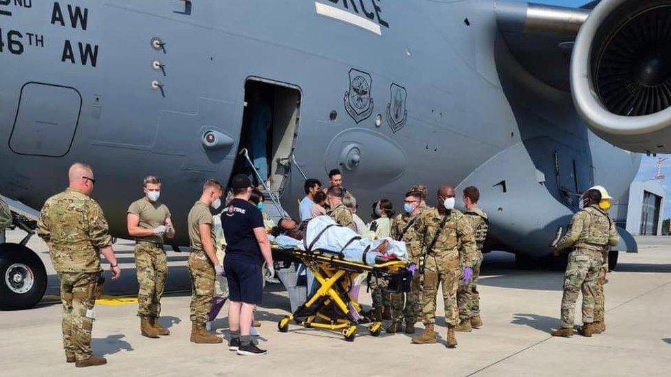 US forces take a mother and new born baby for medical attention after the women gave birth on an evacuation flight from Afghanistan