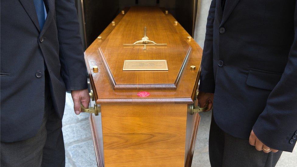 Coffin carriers at funeral (stock photo)