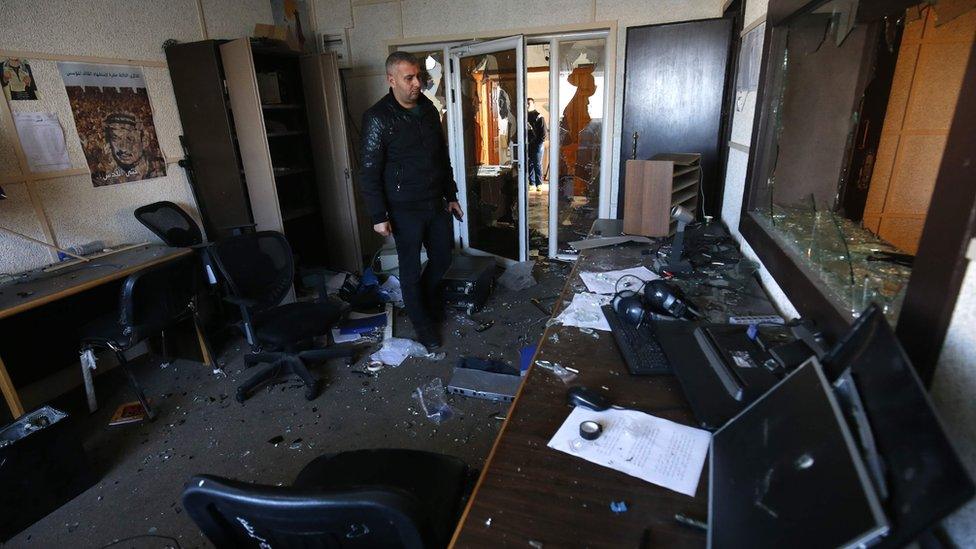 An employee of the Palestinian government-run radio and television stations inspects the damage at one of the studios on January 4, 2019