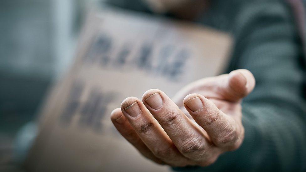 Artistic photo of a man begging on a street