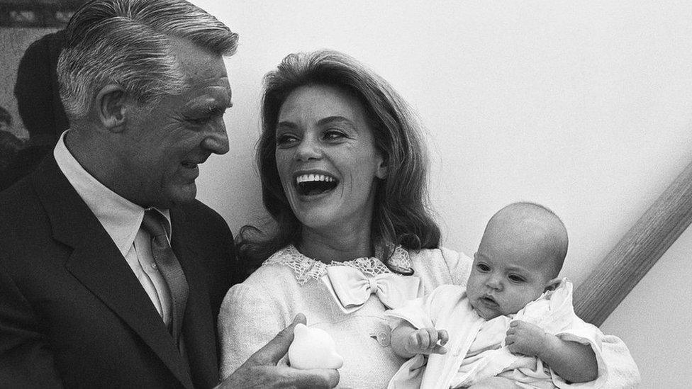 Black and white photo of Cary Grant with his wife Dyan Cannon and their baby daughter Jennifer