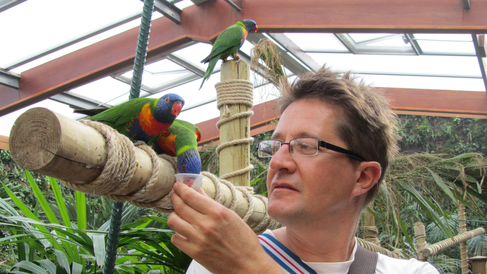 A man giving the birds a drink