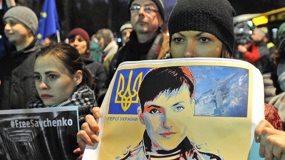 People hold pictures of Ukrainian pilot Nadiya Savchenko during a rally demanding freedom for her, outside the Russian Embassy in Warsaw, Poland, Wednesday, March 9, 2016.