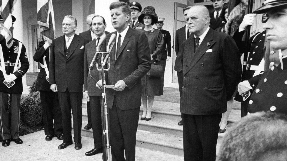 John F Kennedy with Winston Churchill's son Randolph Churchill (to the right of JFK) and David Ormsby Gore (to the left of JFK)