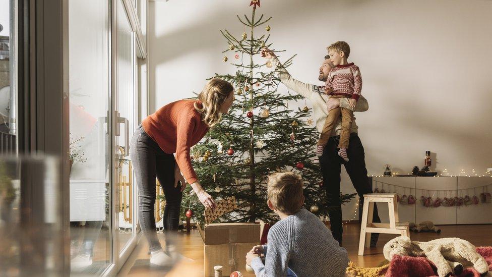 Family decorating Christmas tree