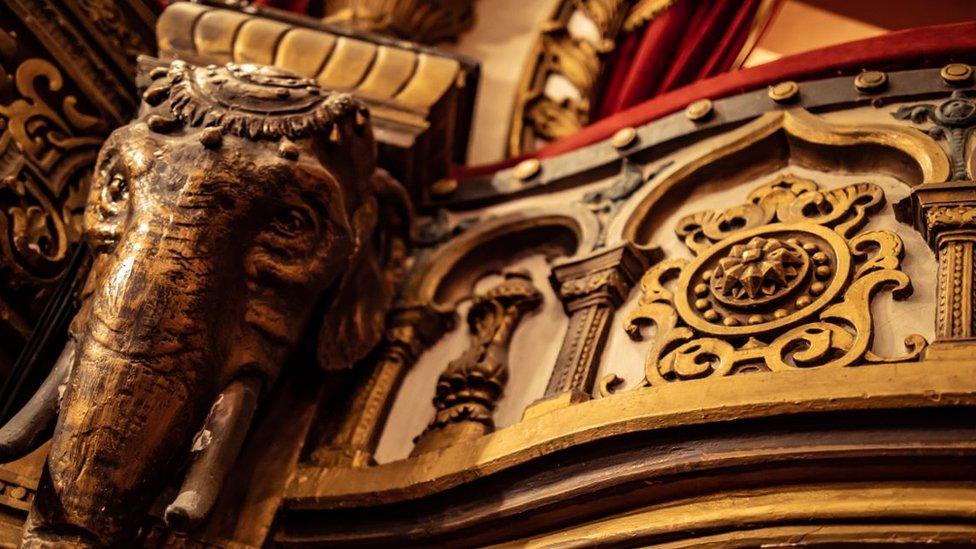 A worn decorative elephant head, among the plasterwork to be restored