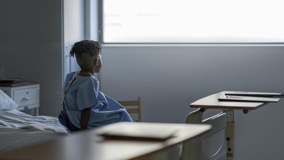 Boy in hospital looking out of window