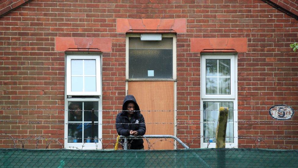 Asylum seeker watching a protest