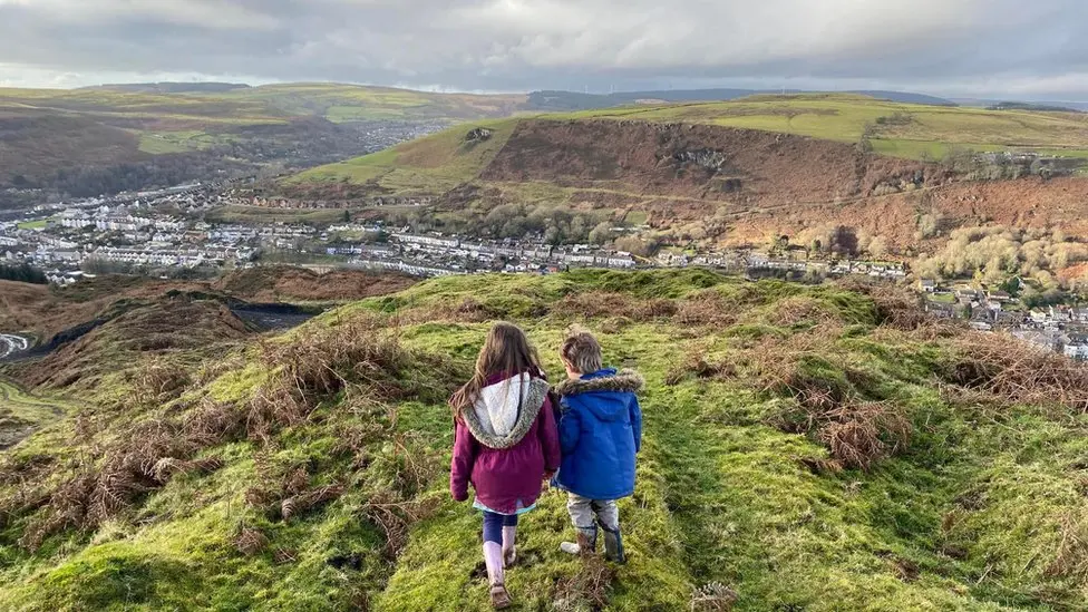 Phil Thomas's children walk on the coal tip near their home.