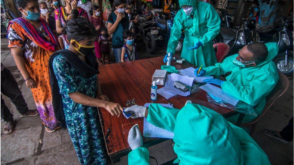 A team of doctors check the temperature and pulse rate of a local residents