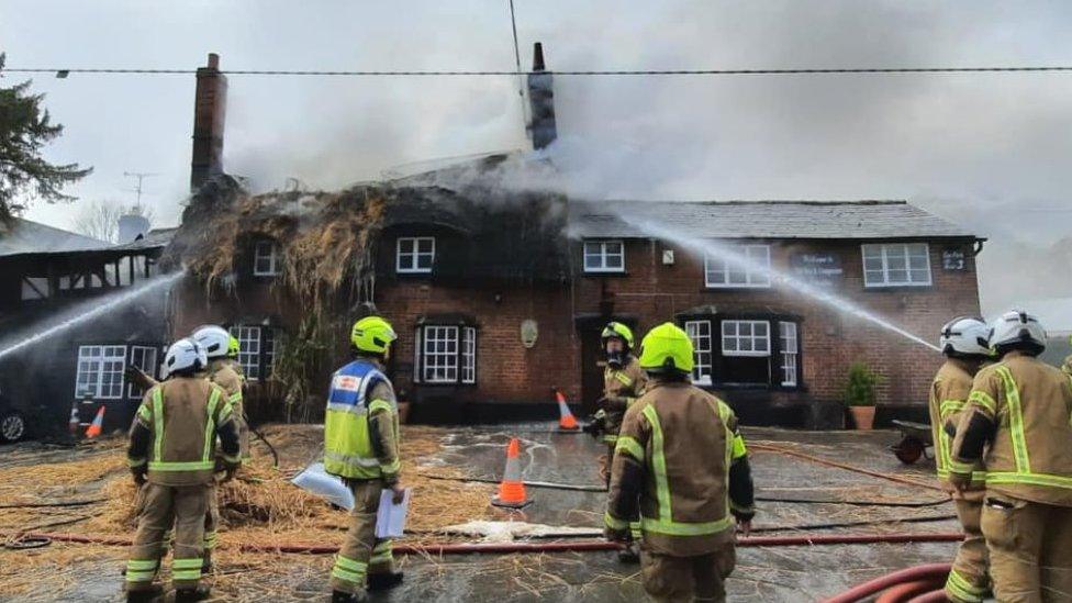 Firefighters tackling a blaze at the Axe and Compasses pub