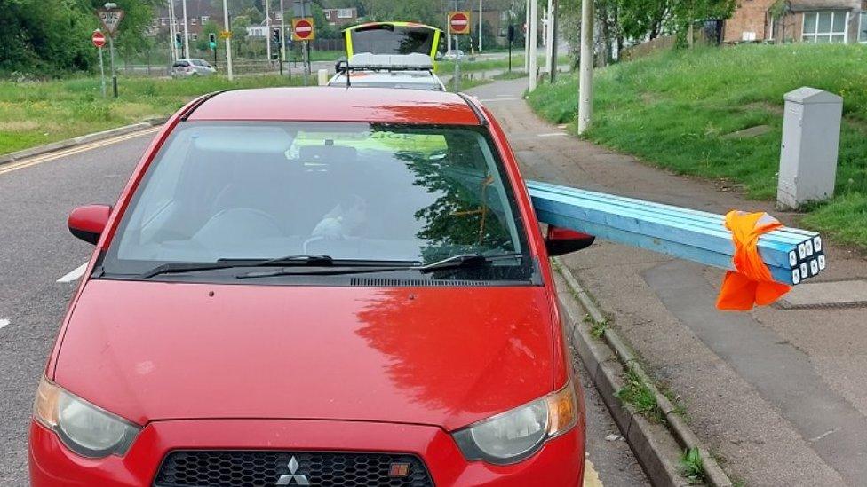 Car with wood sticking out of window