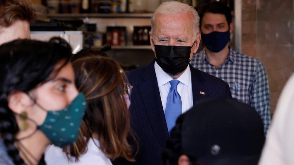 Joe Biden speaks with the staff as he visits the Las Gemelas Taqueria restaurant for carry-out lunch on Cinco de Mayo in the Union Market neighbourhood in Washington,