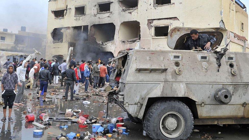 Residents gather outside a police station in North Sinai's provincial capital of El-Arish after it was targeted by a car bomb on 12 April 2015