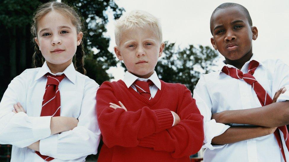 Three kids in school uniform looking powerful