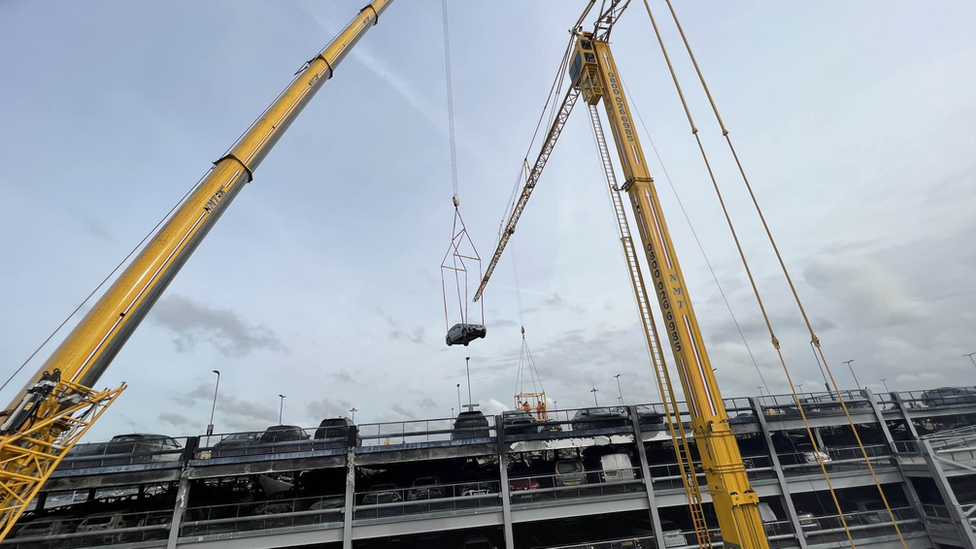 cars being removed on a crane