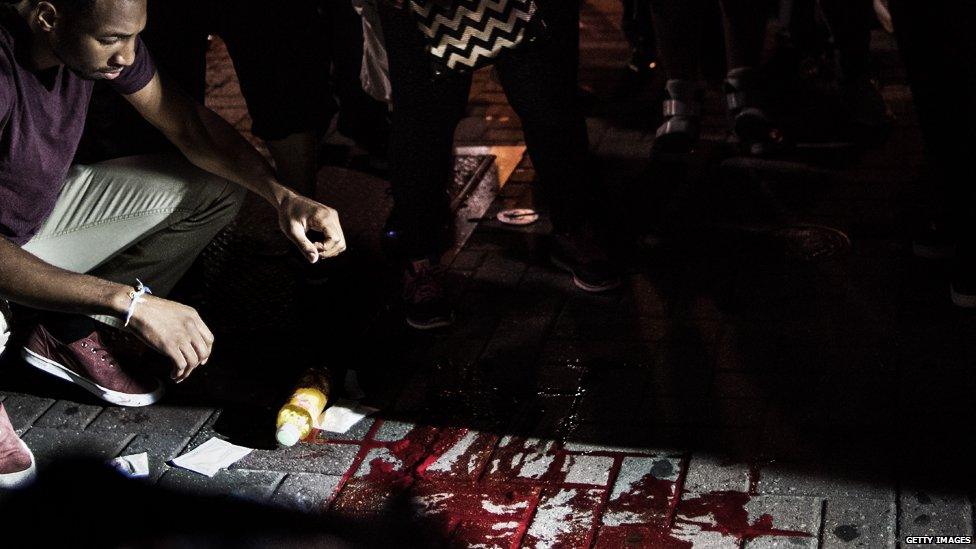 A man looks at blood on the ground