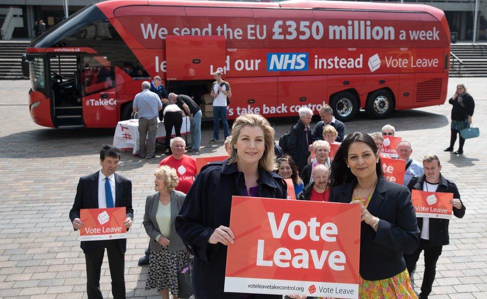 Vote Leave campaigners with a campaign bus behind them that says "We sent the EU £350 million a week"