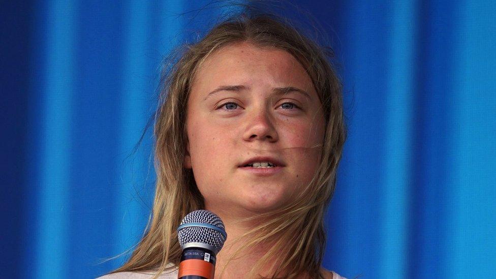 portrait of Greta on stage holding microphone